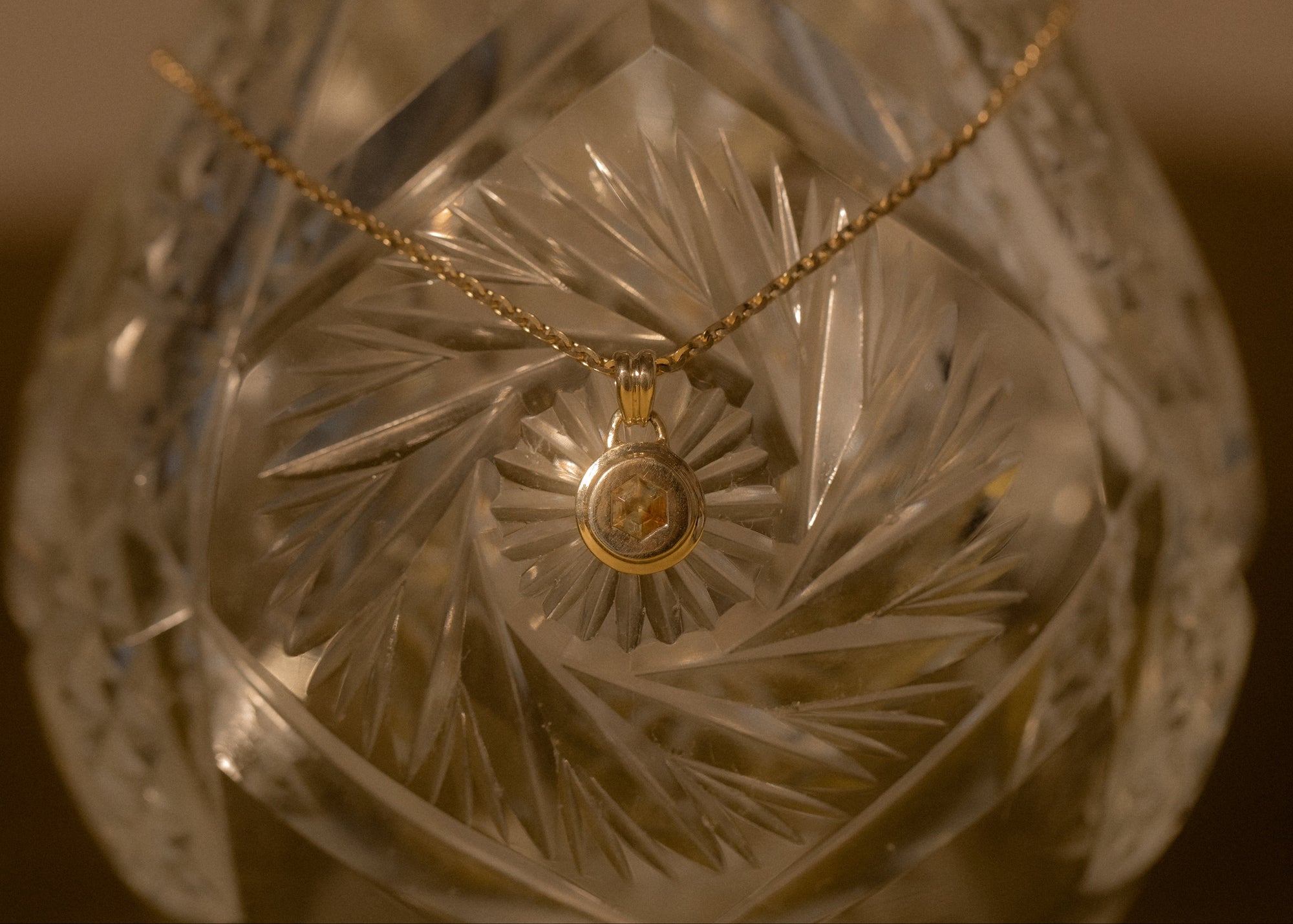 Decorative glass object with a gold necklace draped over it